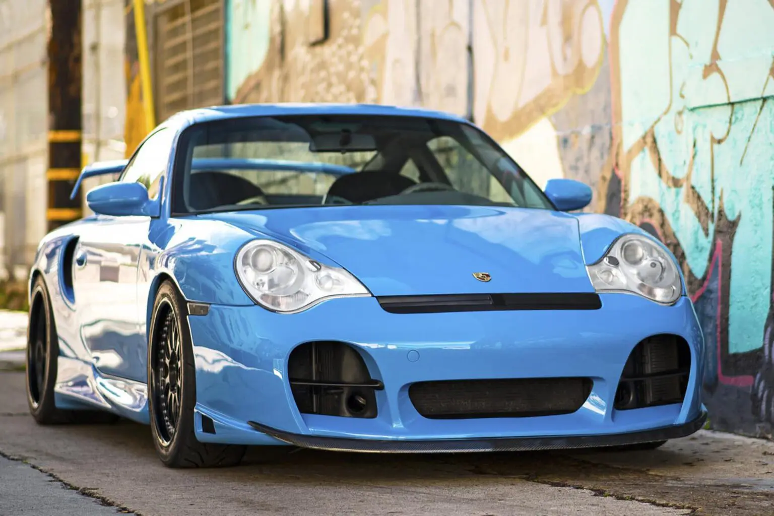 Blue sports car parked on urban street.