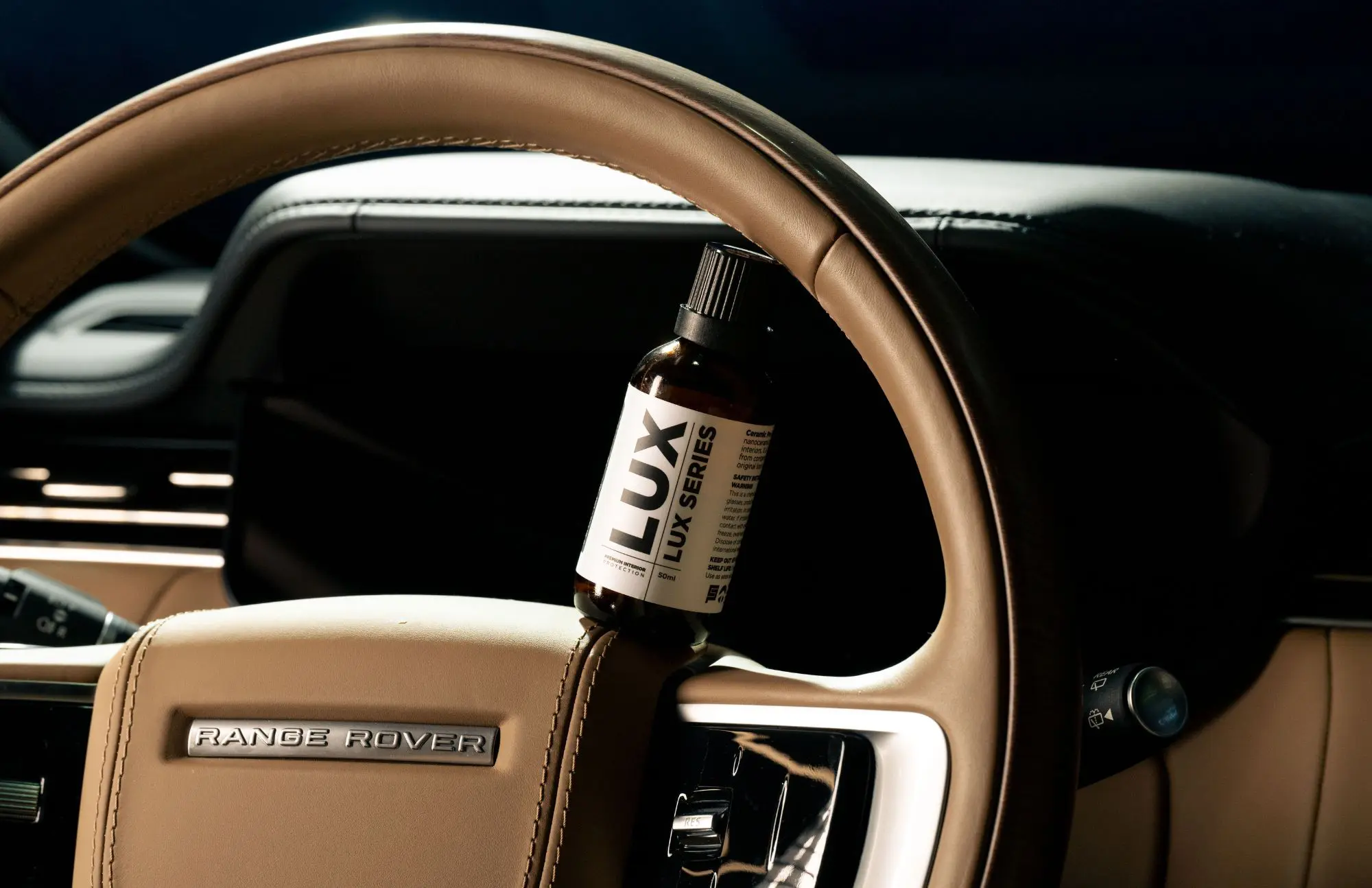 Car steering wheel with Lux product bottle.