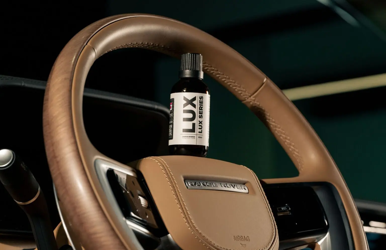 Car steering wheel with Lux bottle displayed.
