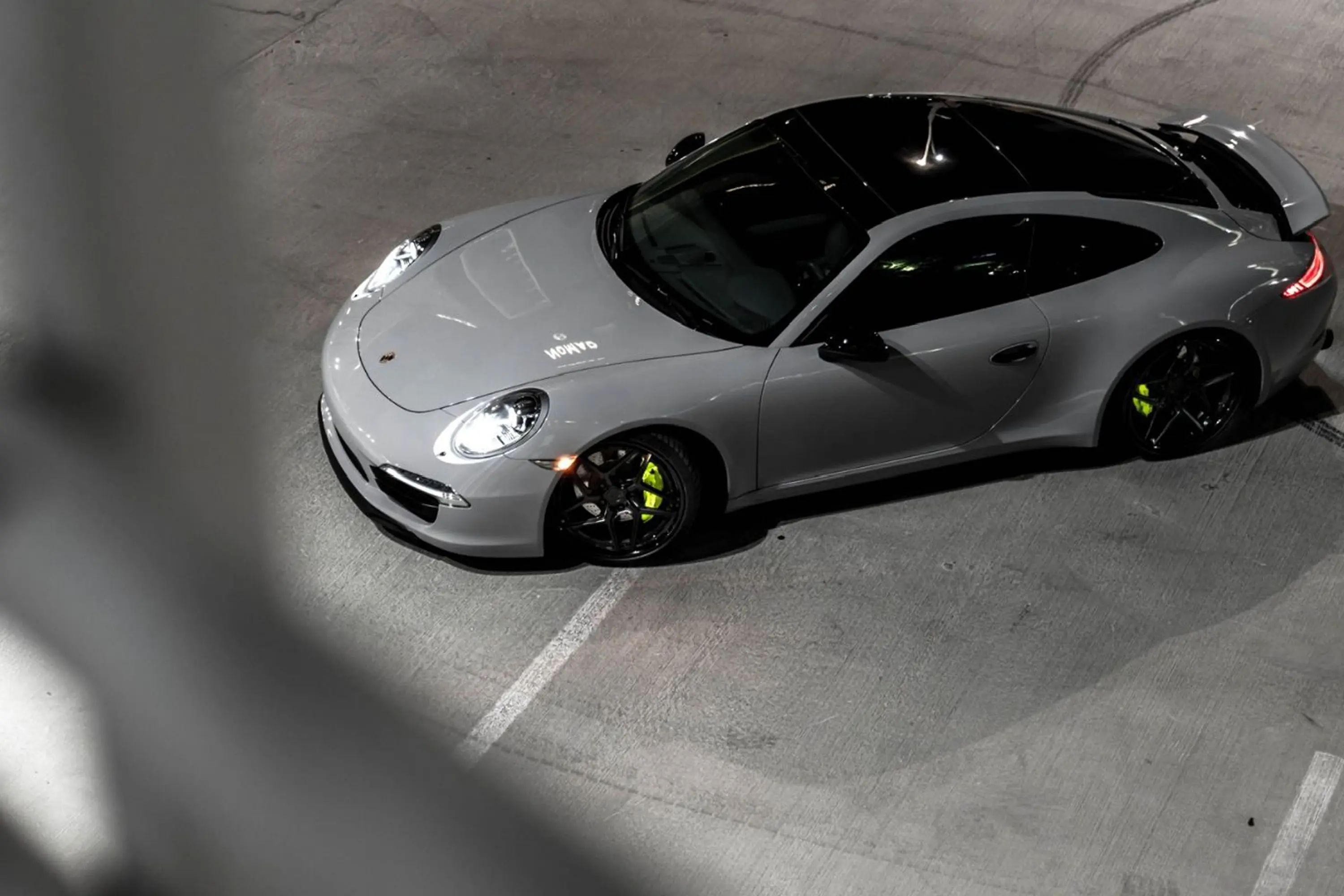Silver sports car parked in dim light.