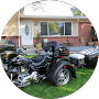 A motorcycle parked in the grass near a house.