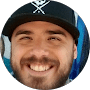 A man with beard and hat smiling for the camera.